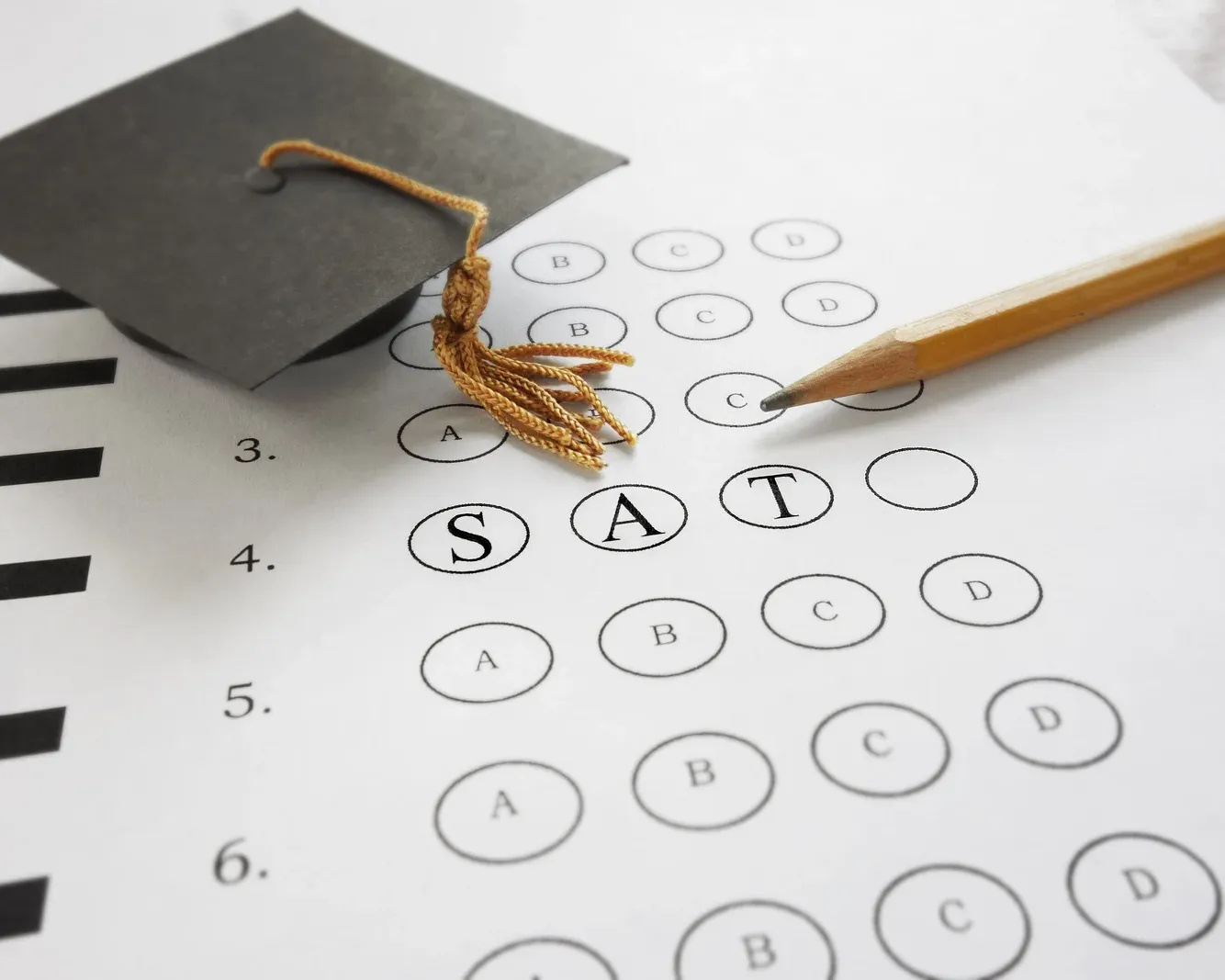 Multiple-choice test sheet marked SAT with a pencil and graduation cap symbolising a high-stakes summative assessment