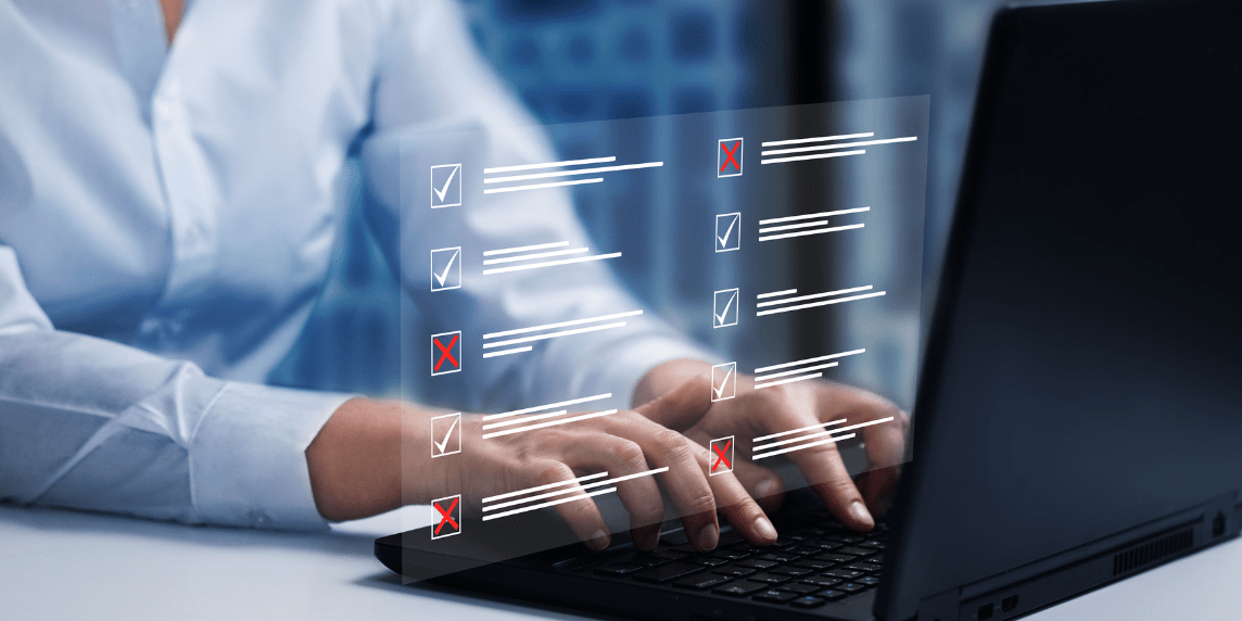Hands typing on a laptop with a digital checklist overlay representing online exam marking and automated assessment tools.