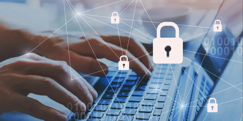 "Hands typing on a laptop keyboard with digital padlock icons representing cybersecurity and data protection.