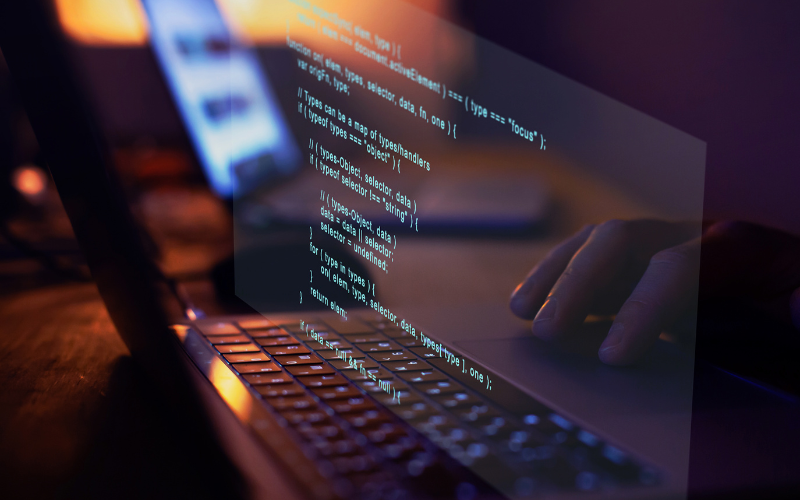 Developer writing code on a laptop to build a custom exam platform